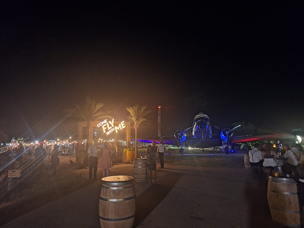 Airliner at night with come fly with me in the distance
